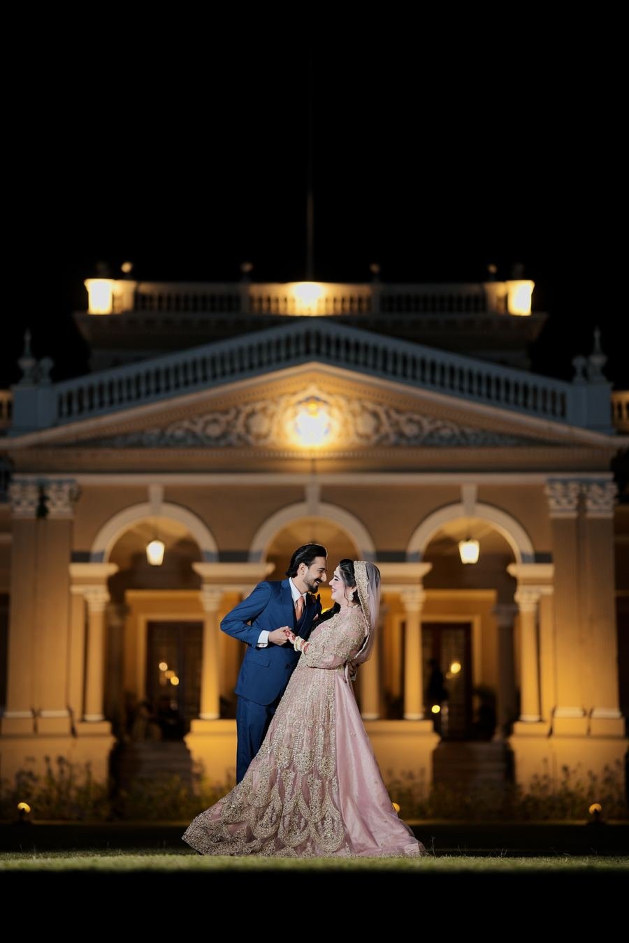 Couple portrait in front of an illuminated palace at night, Bahawalpur